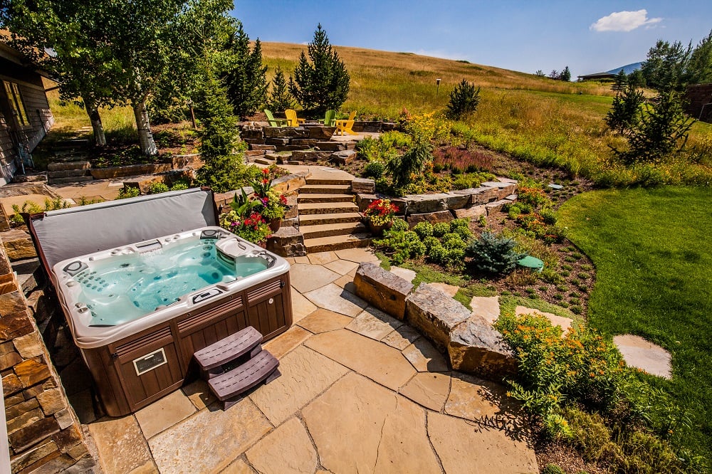 outdoor space with hot tub patio and stairs
