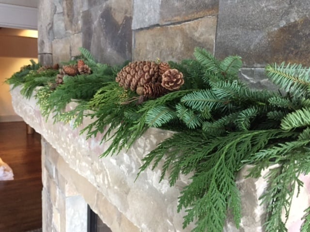 Live greens garland on a fireplace mantle