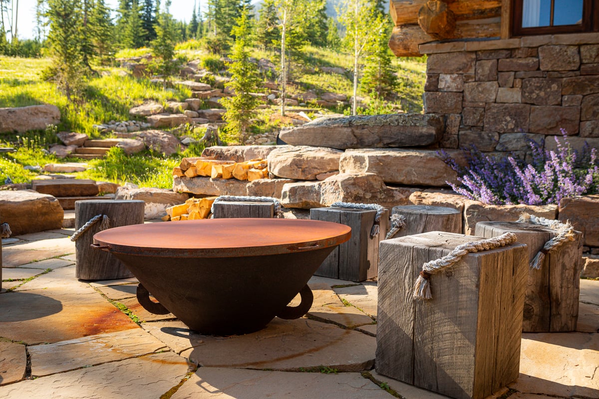 fire pit and patio with rock wall and plantings