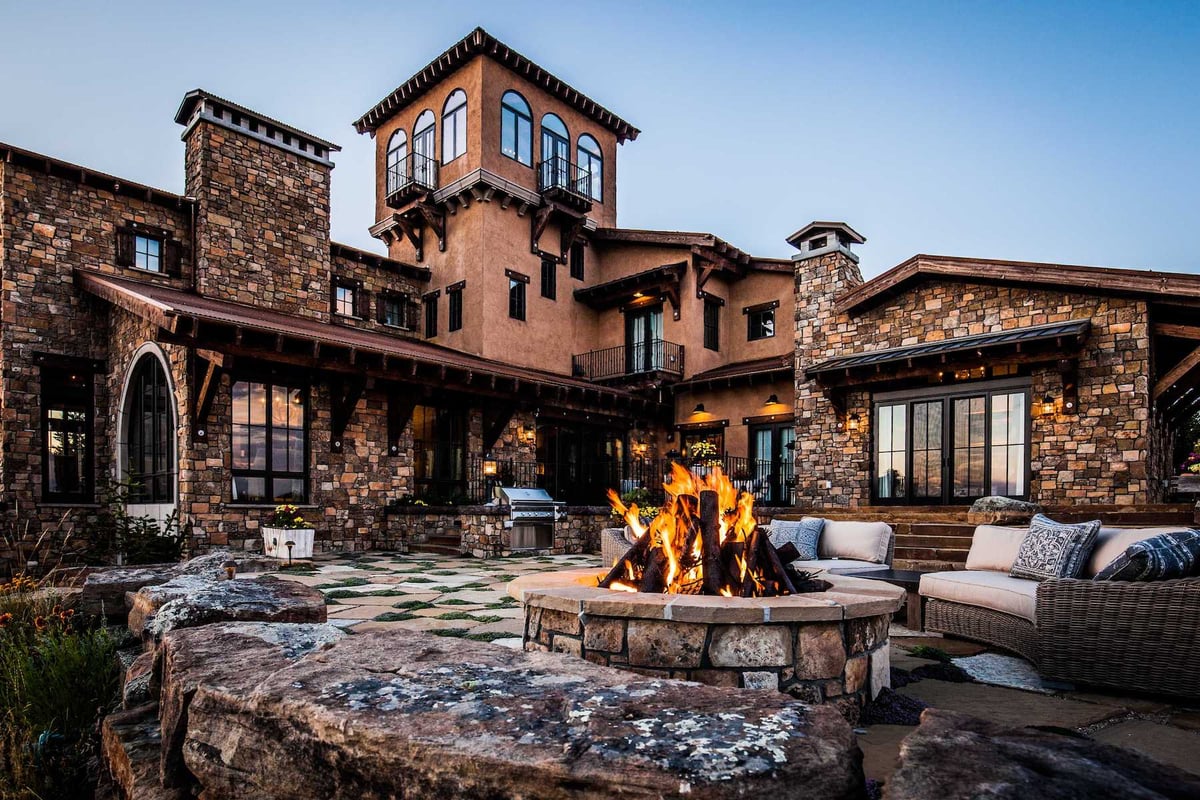 firepit and comfortable seating on flagstone patio with outdoor kitchen