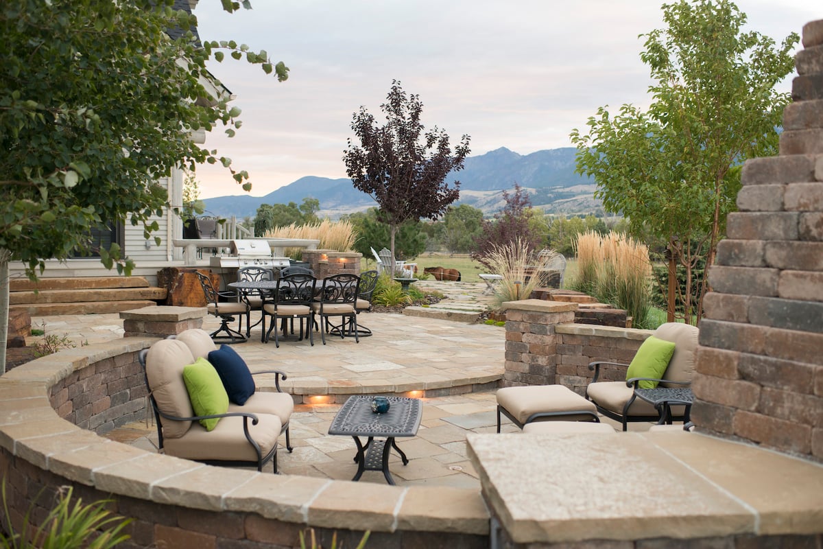 patio with seating near fireplace and outdoor kitchen overlooking mountains