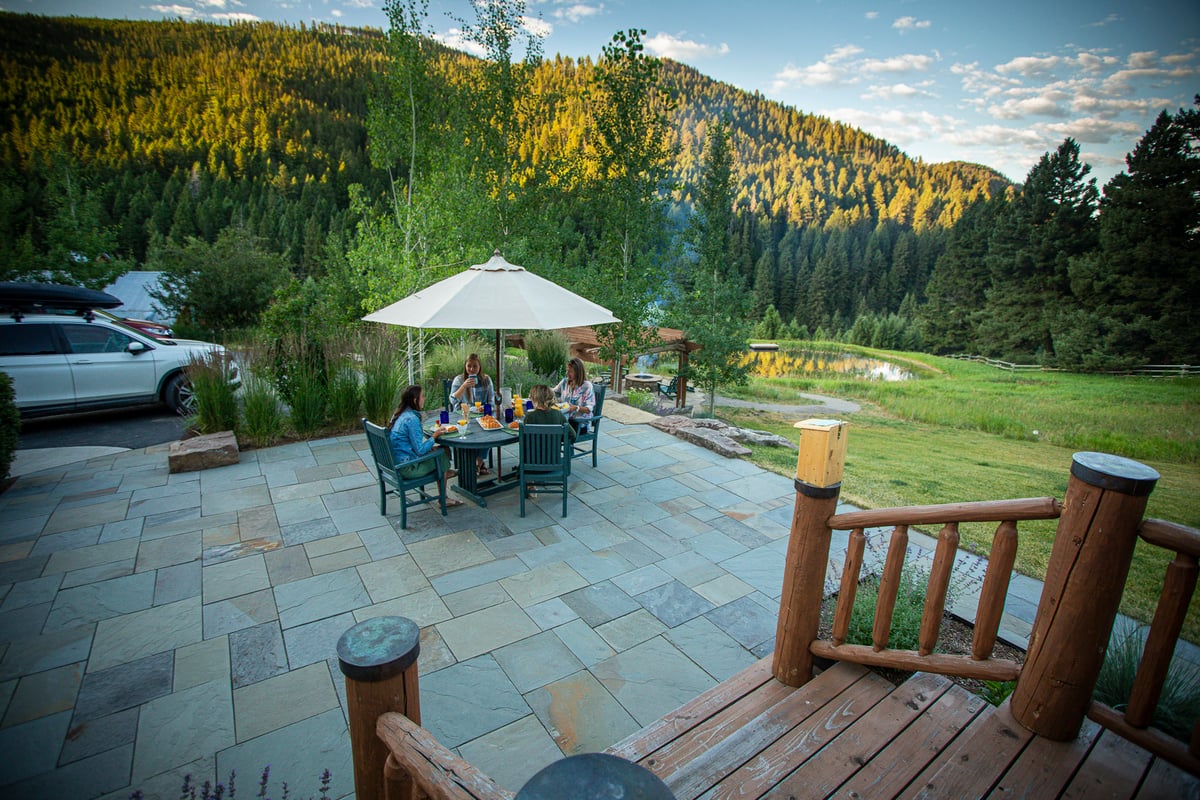 family sitting at table on bluestone patio