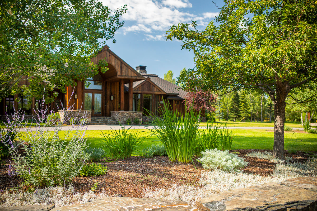 beautifully landscaped home with plantings and stonework