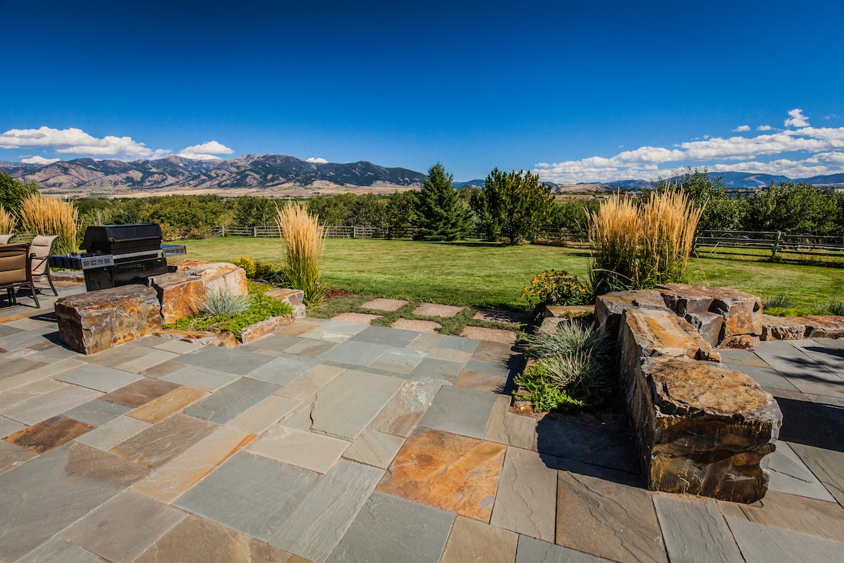 bluestone patio with boulder walls and ornamental grasses