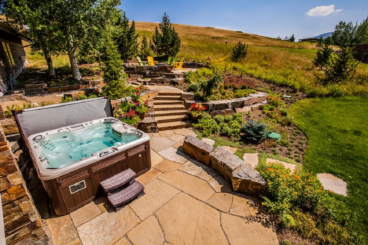 residential landscape with steps, spa, and flowers