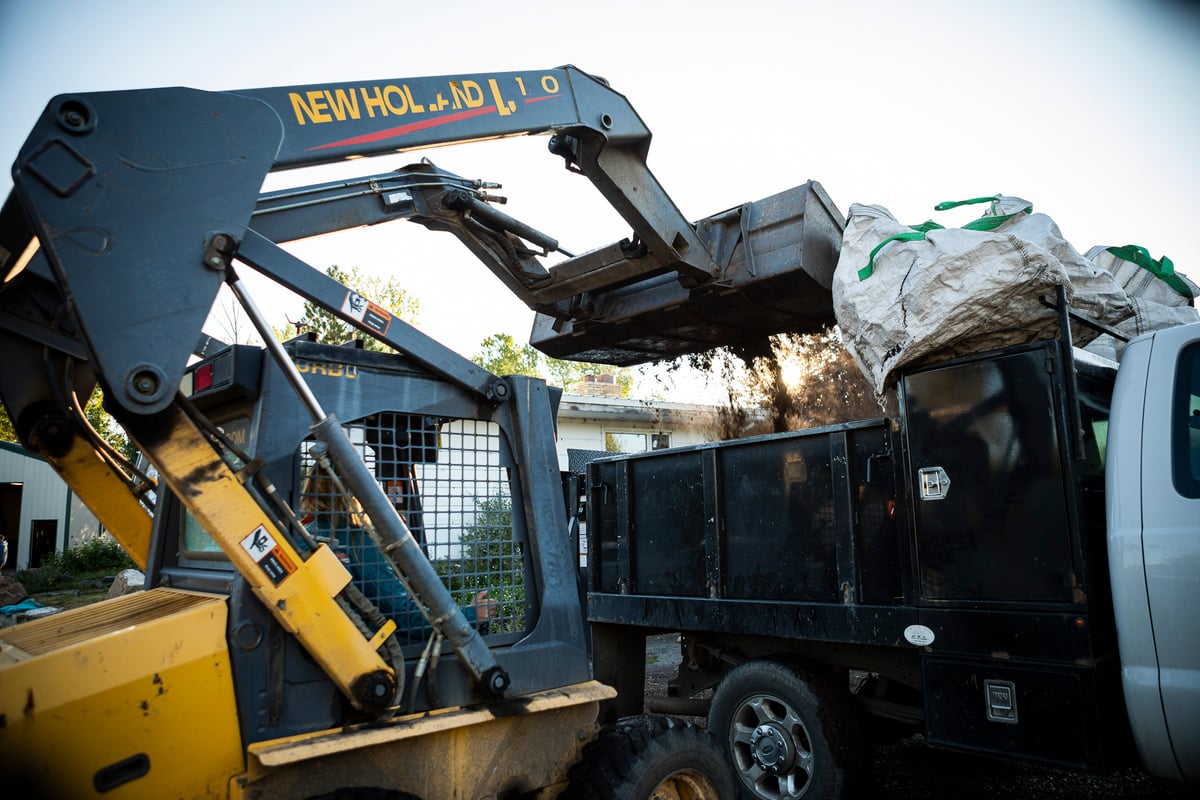 bobcat loading mulch into bed of truck