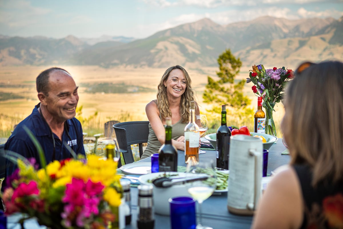 family dines outside on patio in Montana