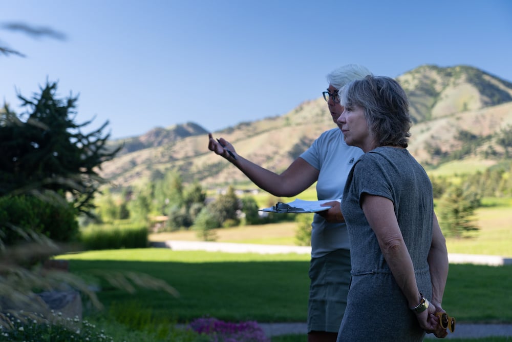 account manager and homeowner inspect yard