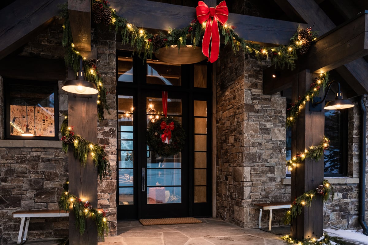 holiday decoration with wreaths and lights at entrance of home