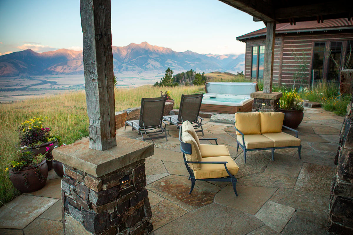 natural stone patio with hot tub and view of mountains