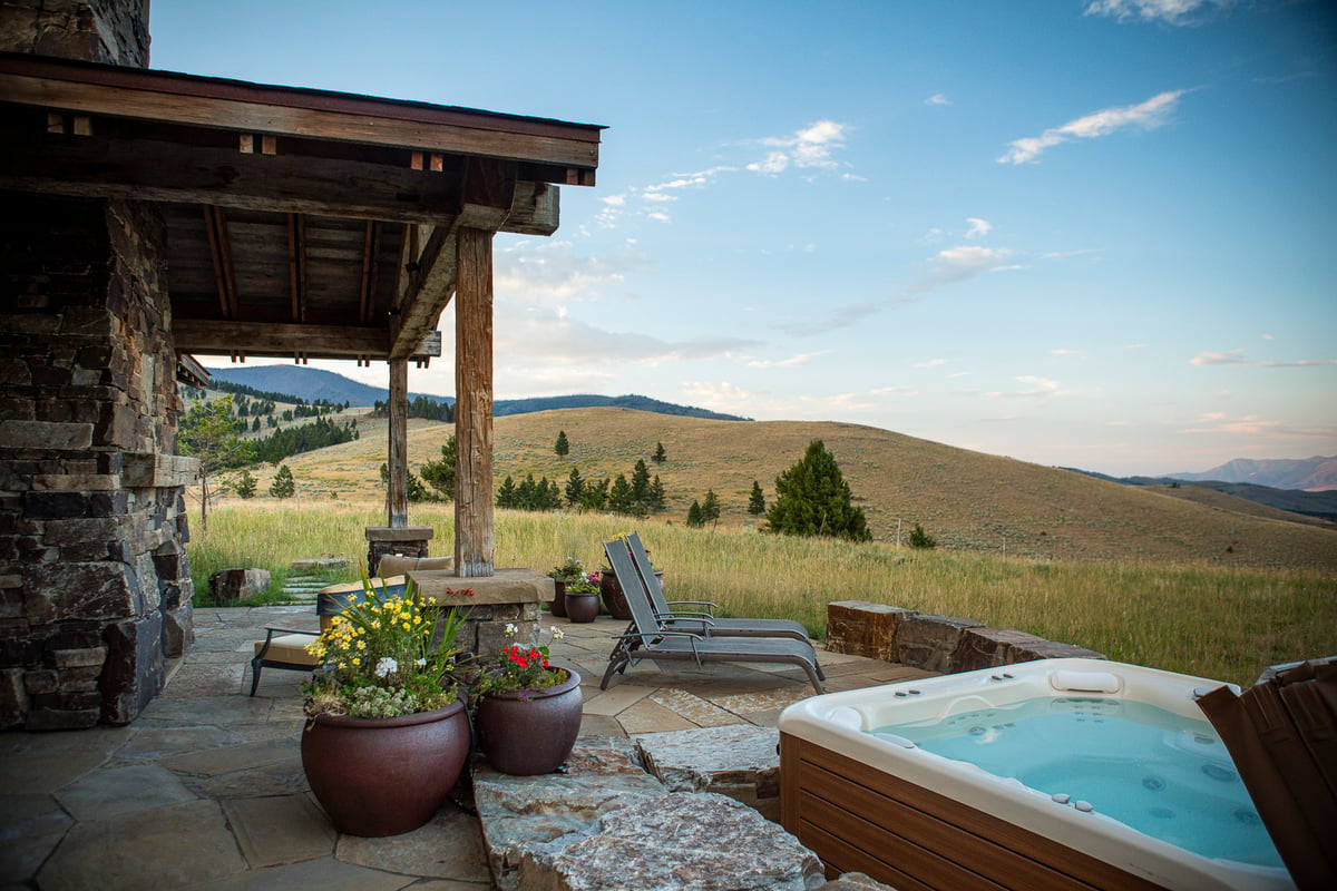 patio with hot tub and view of the mountains