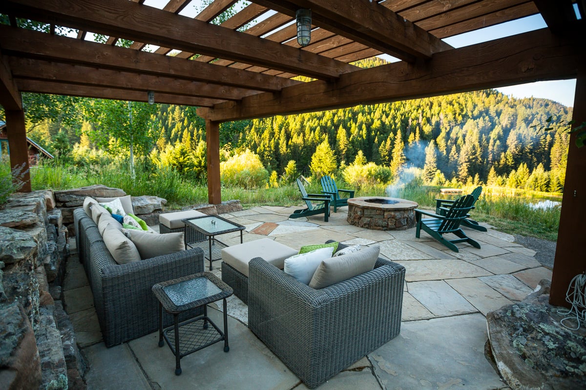 pergola on flagstone patio with comfortable seating and firepit
