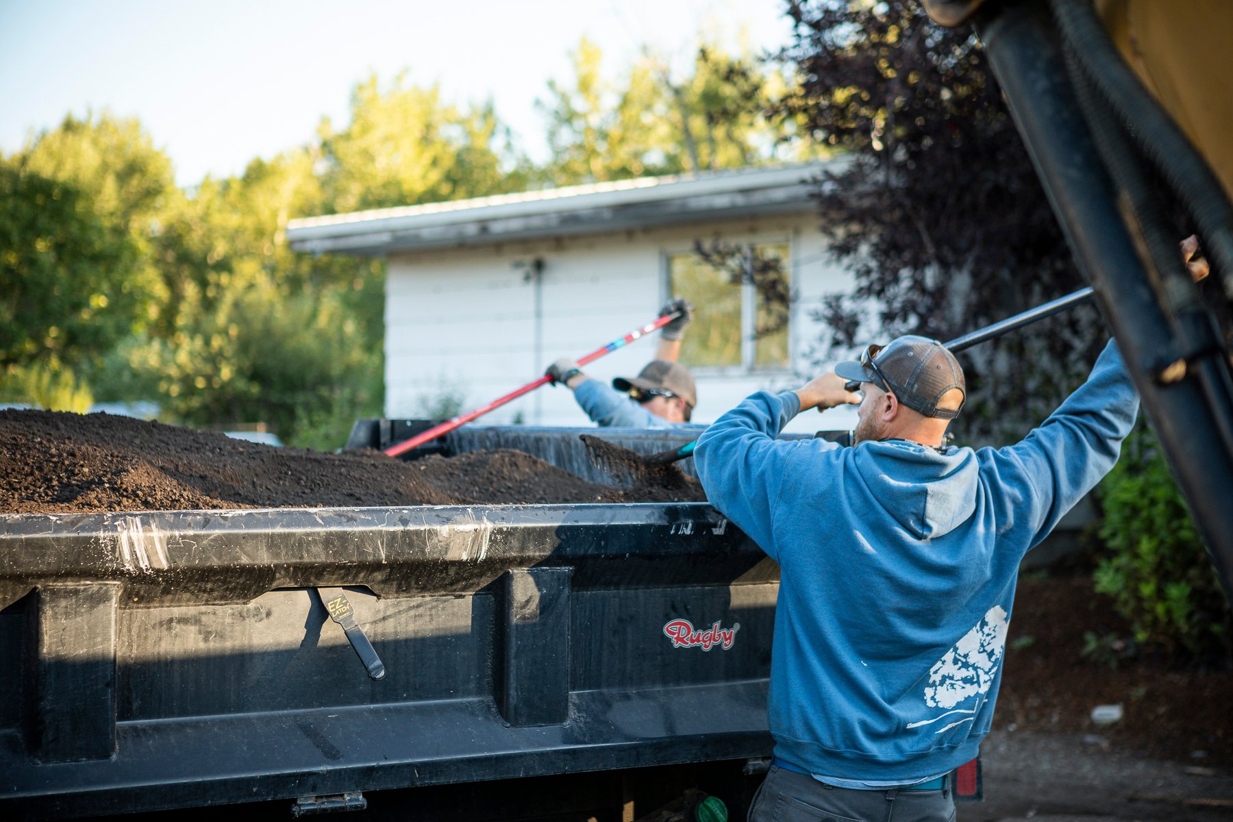 Landscape installation team unloading the trailer