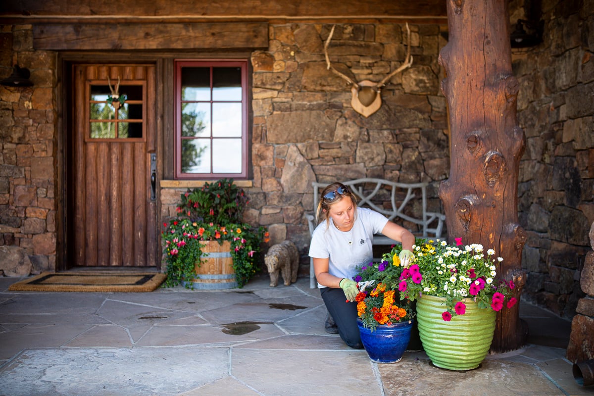 maintenance team helps cut back flowers in container garden